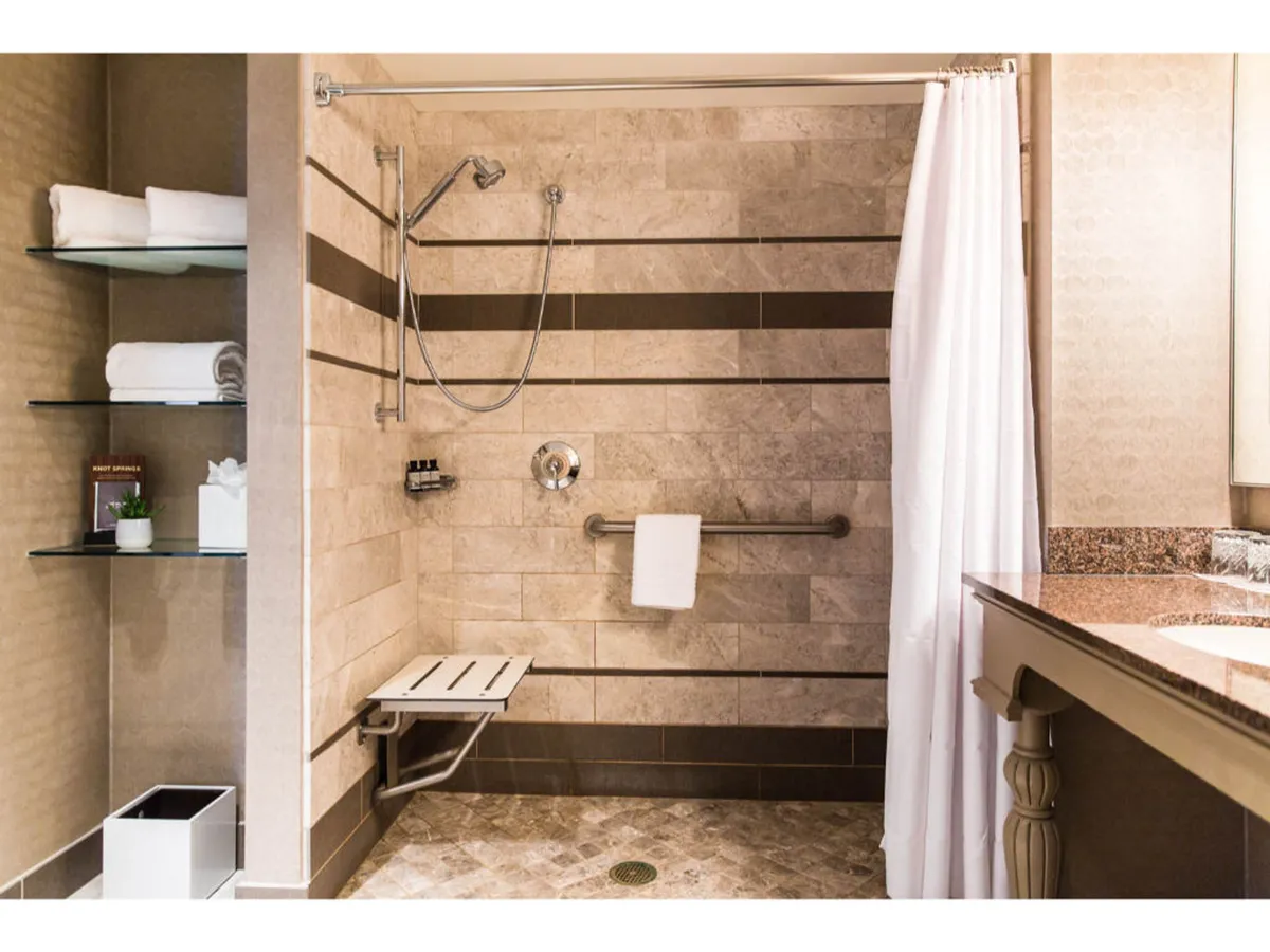 A serene bathroom scene with a spacious shower area, neatly arranged towels, and calming decorative elements, setting a tone of relaxation and self-care.